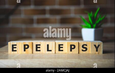 Parola di epilessia su cubi di legno, sfondo. Concetto di epilessia consapevolezza Foto Stock