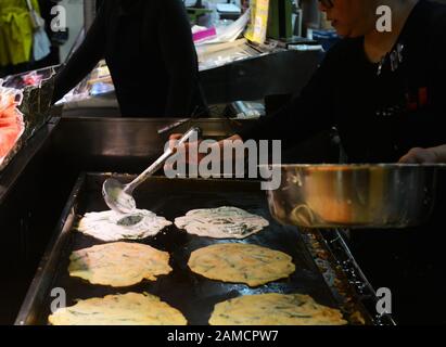 Bancarelle di cibo che vendono pancake salati coreani nel vivace mercato alimentare di Tsuruhashi, Osaka. Foto Stock