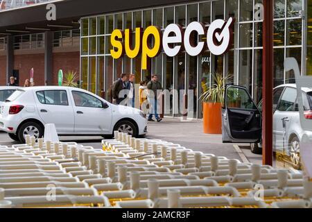 Filari di carrelli (carrelli) con marchio giallo in un supermercato SUPECO in Francia. Foto Stock