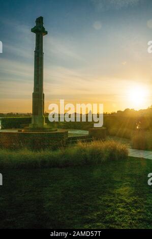 Sole che si trova dietro il memoriale della prima guerra mondiale a Poole Park, Dorset, Inghilterra. Foto Stock