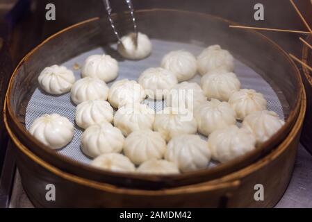 Buns baozi tradizionali al vapore in una vista ravvicinata del vapore di bambù Foto Stock