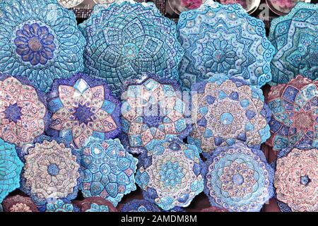 Tradizionale souvenir iraniano - piastre di rame e piatti con motivi floreali ornamento persiano su smalto, Grand Bazaar di Isfahan, Iran Foto Stock
