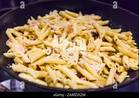 Deliziosa salsa bianca Cremosa abbondante pancetta aglio Penne Pasta in padella padella. Piatto Di Pasta Italiana, Gastronomia, Delicatezza, Cucina, Cibo, Pasto, Din Foto Stock