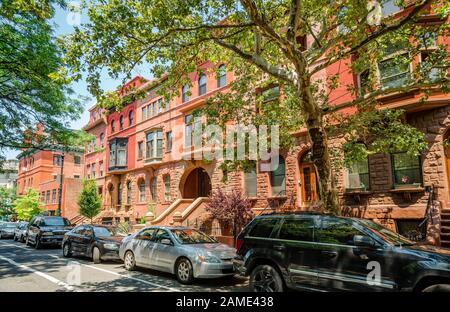 NYC, NY / USA - 12 Luglio 2014: Vista di 120 Street West, a Harlem, Manhattan. Le pietre brownstones dominano l'immagine. Foto Stock