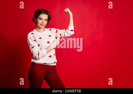 Ritratto di lei bella attraente contenuto allegro marrone-capelli ragazza che dimostra forte muscoli effetto di allenamento isolato su brillante brillante luce brillante Foto Stock