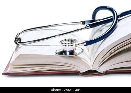 Stetoscopio su un libro, isolato su sfondo bianco. Informazioni mediche Foto Stock