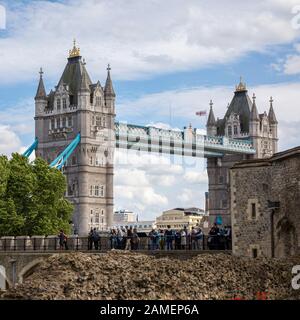 Londra, Regno Unito - 7th giugno 2017: I turisti camminano lungo le mura della Torre di Londra e godono della vista sul famoso Tower Bridge. Nella città Foto Stock