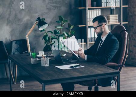 Profilo foto di bello business bruna ragazzo lettura carta rapporto reddito statistiche numeri in cerca di errori indossare specifiche blazer nero camicia vestito Foto Stock