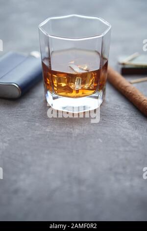 Bicchiere di whisky con ghiaccio, sigaro cubano grande, matches e matraccio d'anca Foto Stock