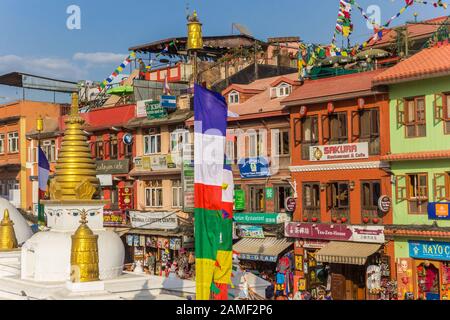 Bandiere di fronte alle case storiche allo stupa Boudhanath a Kathmandu, Nepal Foto Stock