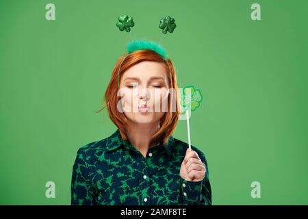 Donna giocosa con occhi chiusi che soffia un bacio Foto Stock