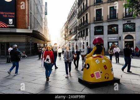 Madrid, Spagna - 1 novembre 2019: Persone in Piazza Callao e via commerciale Preciados con sole splare sullo sfondo. Madrid, Spagna Foto Stock