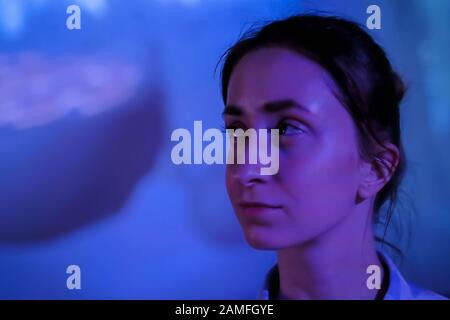 Giovane donna guardando intorno al moderno salone coinvolgente Foto Stock