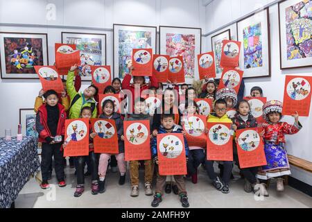 (200113) -- CIXI, 13 gennaio 2020 (Xinhua) -- Gli Studenti mostrano i loro dipinti a tema su un Capodanno cinese lunare in un centro culturale nella città di Henghe di Cixi, nella provincia di Zhejiang della Cina orientale, 13 gennaio 2020. Il centro di Servizio Volontario di Qian Haijun e lo studio di pittura contadina di Zhu Biyun a Cixi hanno tenuto lunedì la prima di una serie di lezioni d'arte in un centro culturale nella città di Henghe. Più di 20 studenti delle scuole primarie, compresi i bambini locali e i figli migranti del gruppo etnico Zhuang e Miao, hanno partecipato a questa attività e hanno imparato la pittura degli agricoltori sotto la guida della pittura degli agricoltori arti Foto Stock