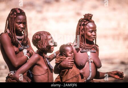 Le donne himba e bambini in Kaokoveld, il villaggio tribale della Namibia, Africa Foto Stock