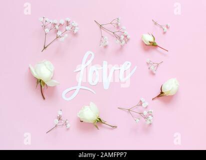 Fiori e LETTERE D'AMORE su uno sfondo rosa chiaro vista dall'alto Foto Stock