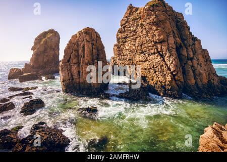 Spiaggia Di Ursa, Sintra, Portogallo. Epiche rocce di mare che si innalzano dall'oceano atlantico alla luce del tramonto Foto Stock