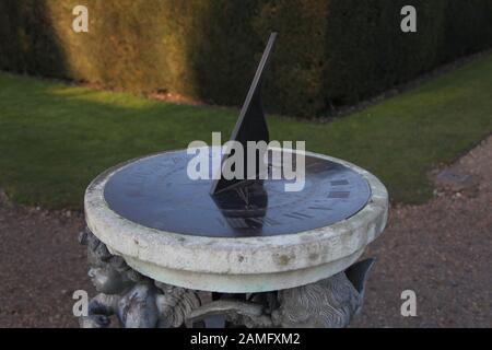 Primo piano di cherub Sundial situato nei giardini di Polesden Lacey, un sito del National Trust a Great Bookham, Surrey, Inghilterra, Regno Unito, gennaio 2020 Foto Stock