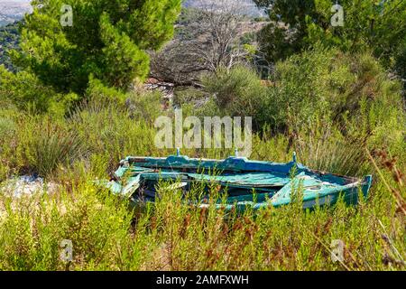 Una barca a remi deserta sulla terra Fotografata sull'isola greca di Cefalonia, Mar Ionio, Grecia Foto Stock