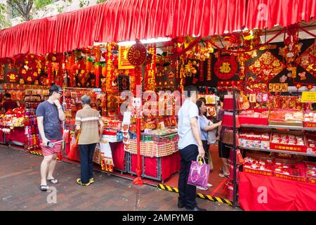 La gente cinese cammina attraverso il mercato all'aperto festivo per dare un'occhiata a varie merci e decorazioni cinesi di Capodanno, Singapore Foto Stock