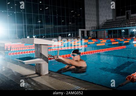 bel nuotatore in occhiali da ginnastica in piscina Foto Stock