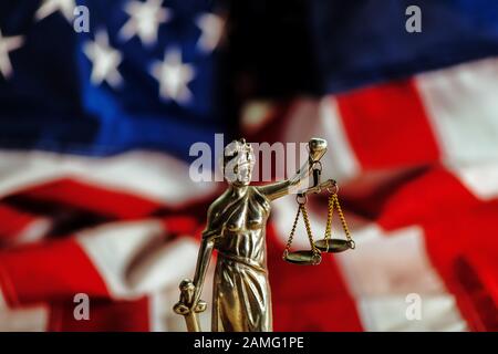 Diritto e Giustizia in Stati Uniti d'America, la statua della Madonna della giustizia con la bandiera degli Stati Uniti in background, il fuoco selettivo Foto Stock