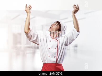 Giovane chef maschile con un cartello bianco vuoto Foto Stock