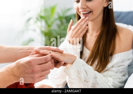 vista corta dell'uomo che fa la proposta di matrimonio alla donna scioccata Foto Stock