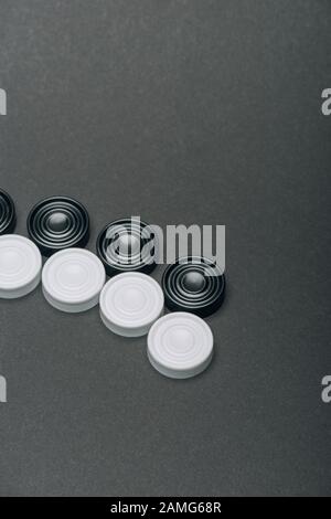 Righe di pedine bianche e nere isolate su grigio Foto Stock