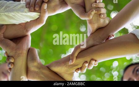 Il lavoro di squadra unisce il concetto insieme della mano, il team di affari che si leva in piedi le mani insieme, lavoro di carità del Volontario. Persone che si uniscono per il successo della cooperazione Foto Stock