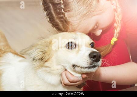 Una bambina abbraccia il suo amato cane. Close up Foto Stock