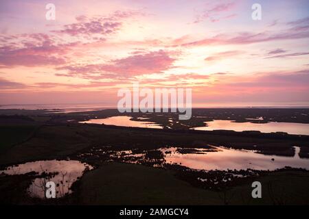Un tramonto alla fine di dicembre visto da Warton Crag su Morecambe Bay con saltmarsh in primo piano. La baia è nota per i suoi tramonti mozzafiato Foto Stock