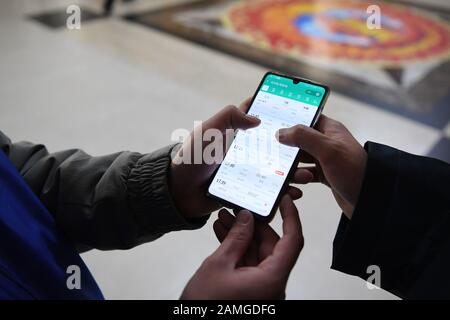 (200113) -- LANZHOU, 13 gennaio 2020 (Xinhua) -- un volontario aiuta un passeggero a controllare le informazioni del treno alla stazione ferroviaria di Lanzhou a Lanzhou, capitale della provincia di Gansu della Cina nord-occidentale, 13 gennaio 2020. Durante la corsa di corsa del Festival di Primavera, la Stazione ferroviaria di Lanzhou e la Stazione ferroviaria Ovest di Lanzhou lanciano uno speciale servizio volontario chiamato 'il ritorno del viaggio'. Per i passeggeri che hanno effettuato appuntamenti, che sono in fretta di salire sui treni o non hanno familiarità con il sistema di biglietteria mobile, i volontari sono lì per fornire il servizio e aiutarli a ridurre il tempo di salire sui treni, portando Foto Stock