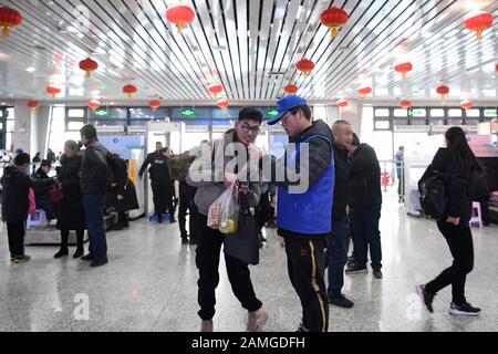 (200113) -- LANZHOU, 13 gennaio 2020 (Xinhua) -- un volontario fornisce servizio a un passeggero alla stazione ferroviaria di Lanzhou a Lanzhou, capitale della provincia di Gansu della Cina nord-occidentale, 13 gennaio 2020. Durante la corsa di corsa del Festival di Primavera, la Stazione ferroviaria di Lanzhou e la Stazione ferroviaria Ovest di Lanzhou lanciano uno speciale servizio volontario chiamato 'il ritorno del viaggio'. Per i passeggeri che hanno effettuato appuntamenti, che sono in fretta di salire sui treni o non hanno familiarità con il sistema di biglietteria mobile, i volontari sono lì per fornire il servizio e aiutarli a ridurre il tempo di salire sui treni, portando i passeggeri con Foto Stock