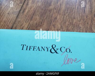 Primo piano del logo per Tiffany and Company, con colore blu caratteristico, su carta su sfondo di legno, San Ramon, California, 27 novembre 2019. Nel novembre 2019, la società ha annunciato che sarebbe stata acquisita dalla società francese LVMH. () Foto Stock