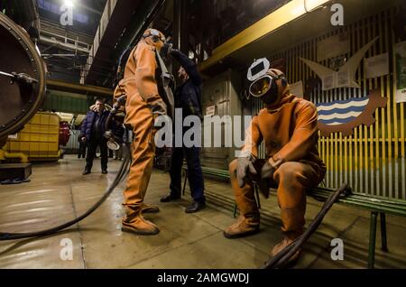 Preparazione per la saldatura ad argon in una camera senza aria. Saldatrici in abiti speciali Foto Stock