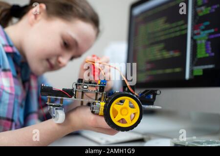 Studente Femminile Costruzione Robot Car In School Science Lezione Foto Stock