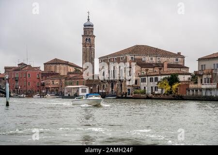 Venezia, ITALIA - 29 ottobre 2019: Paesaggio urbano con argine dei canali e campanile della chiesa di san Pietro martyre, sparato il 29 ottobre 2019 in un'atmosfera luminosa e torbida Foto Stock