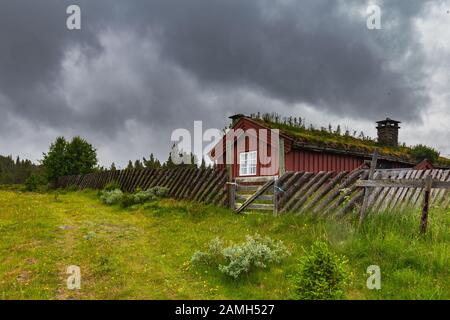 Tipica casa rossa norvegese in legno nel freddo tempestoso lungo Peer Gynt Vegen nella Norvegia occidentale vicino a Gala Foto Stock