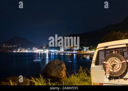 Bellissimo tramonto sulla costa mediterranea. Baia pittoresca con camper in Montenegro. Foto Stock