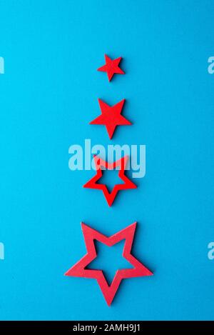 Albero di Natale alternativo fatto di stelle rosse o su uno sfondo blu Foto Stock