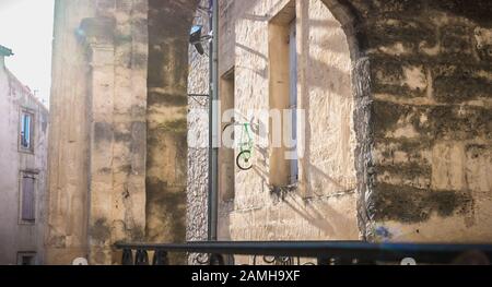 Montpellier, Francia - 2 gennaio 2019: Bicicletta per bambini appesa a un muro nel centro storico della città da un anonimo artista con lo pseudonimo di BMX Foto Stock