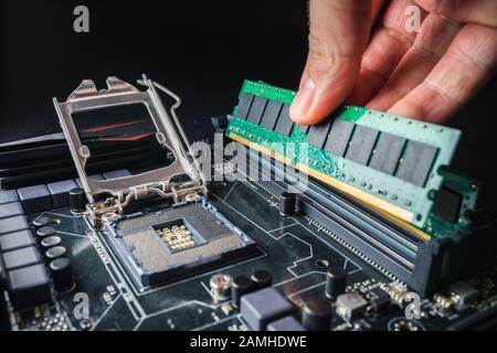 Installazione di una nuova memoria RAM DDR per un socket di un processore per personal computer in un servizio. Aggiornamento della riparazione. Concetto di aggiornamento o riparazione del PC. Foto Stock