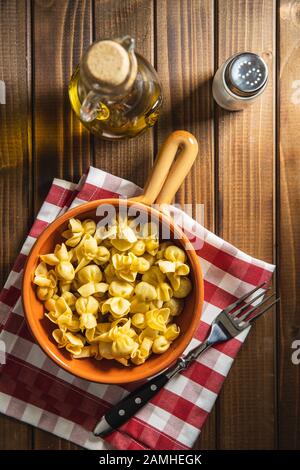 Pasta italiana farcita. Pasta SACCHETTINI in ciotola su vecchio tavolo da cucina. Disposizione piatta. Foto Stock