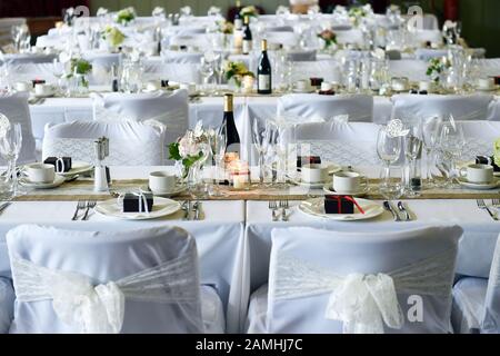 Tavoli e sedie per matrimoni preparati per la grande festa con vino e regali. Foto Stock