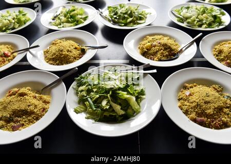 Il cibo del ricevimento per matrimoni è pronto per il tavolo, il couscous e l'insalata in grandi ciotole per la condivisione. Foto Stock