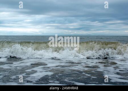 Onde oceaniche durante la tempesta. L'acqua rotola in avanti e bolle a riva, forza della natura e polvere beatyful acquamarine blu . Foto Stock