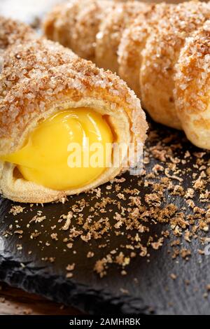 Dolci farciti con crema alla vaniglia su ardesia Foto Stock