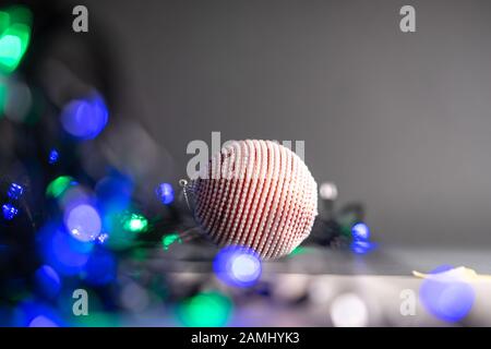 Palle di natale giallo, rosso e viola e luci garland. Messa a fuoco selettiva Foto Stock