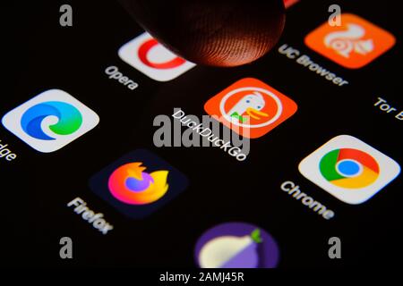 App browser Internet DuckDuckGo circondata da concorrenti e un dito dell'utente che lo seleziona. Concetto di concorrenza. Foto macro. Foto Stock